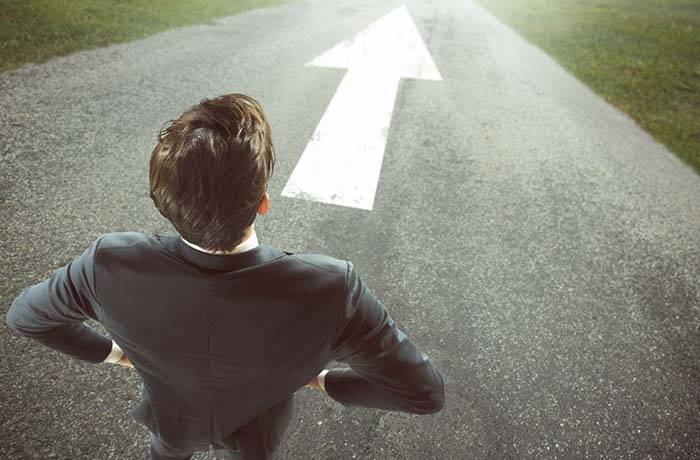 Businessman with big arrow on the road